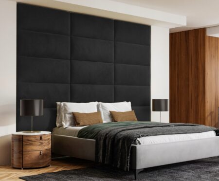 Modern bedroom with double bed and black upholstered wall panels on the wall